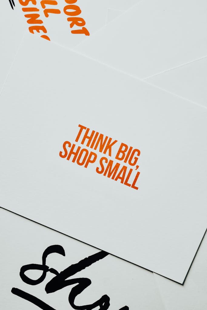 Close-up of a card featuring the motivational message 'Think Big, Shop Small' in orange text on a white background.