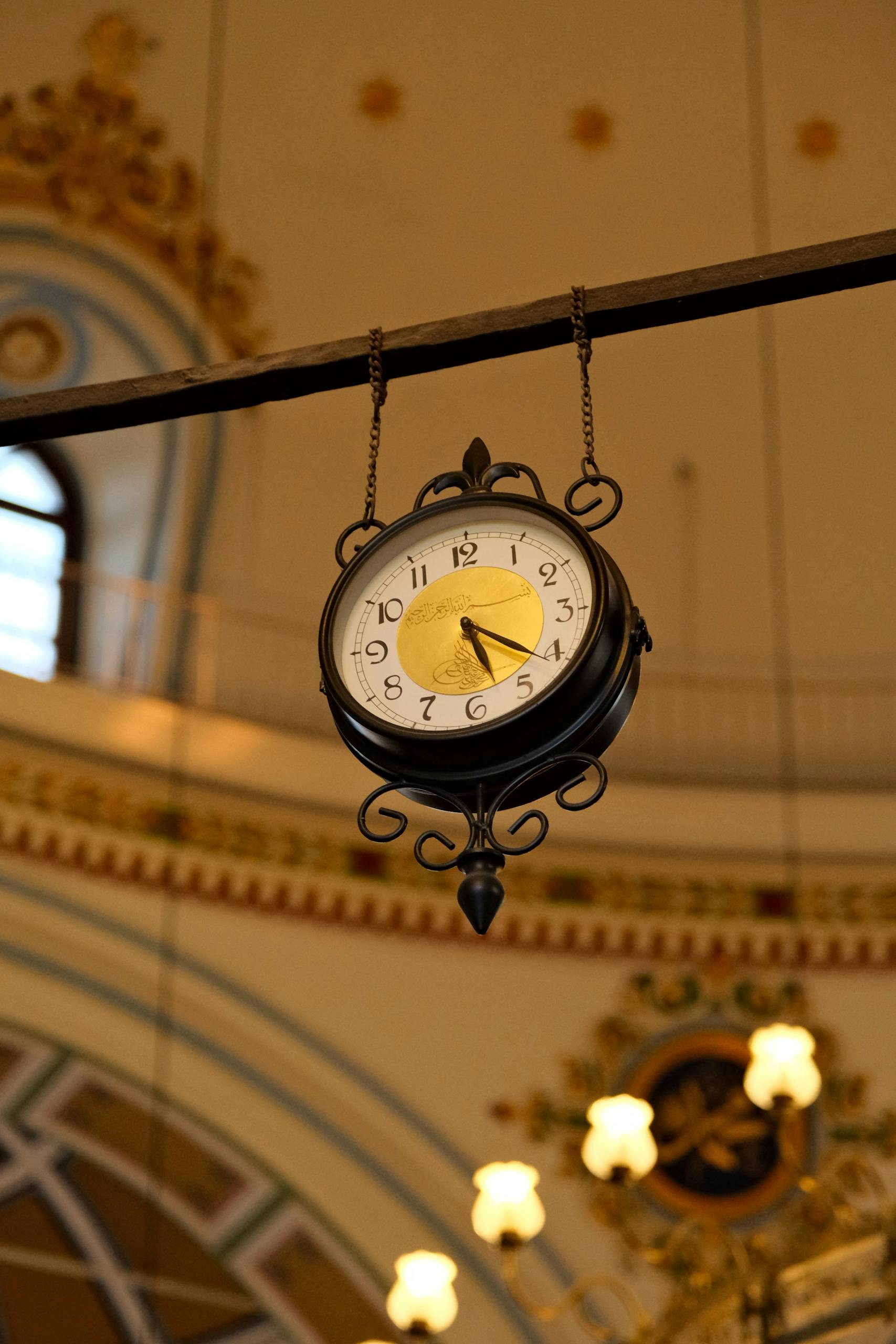 Elegant vintage clock hanging in ornately decorated interior, warm ambiance.